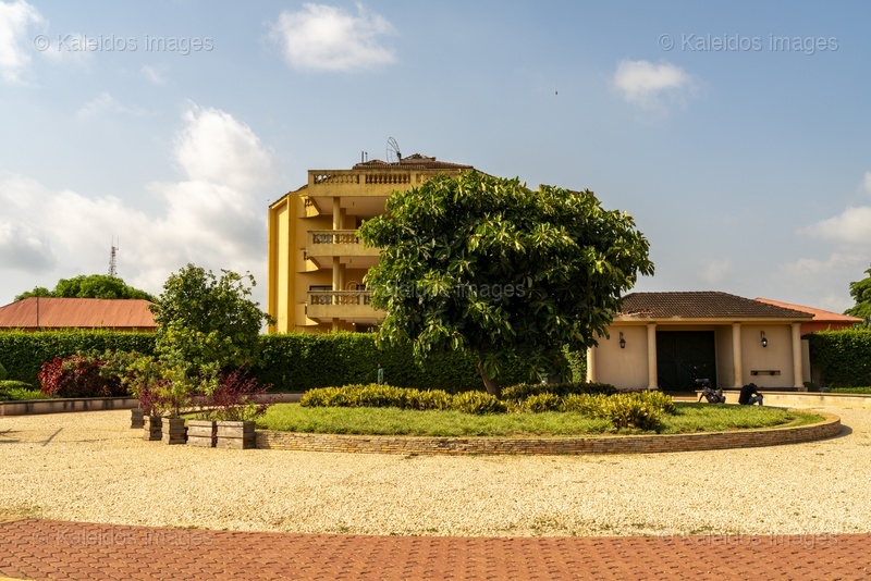 Place des Enchères Ouidah ; Place Chacha slave market Benin ; bronze sculptures slave trade ; spheres ground memorial Ouidah ; monumental heads Xweda Fon Yoruba ; memorial public art West Africa ; night lighting Ouidah square ; red laterite ground ; de Souza house Singbomey ; Afro-Brazilian heritage Ouidah ; Benin Revealed program
