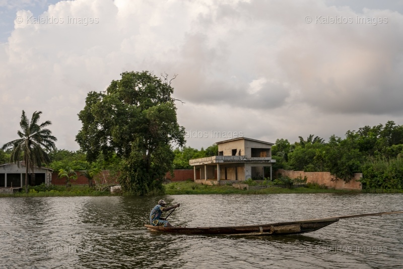 Lake Toho;Ouidah;Benin;West Africa;fisherman;Man;pirogue;paddle;Shirt;lake crossing;pole;overcast sky;traditional transport;everyday life;West Africa;Tarek Charara;Kaleidos;Kaleidos images;La parole à l'image