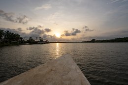 Lac-Toho;Ouidah;Bénin;Afrique-de-lOuest;coucher-de-soleil;heure-dorée;pirogue;proue;ciel-orange;nuages;reflet-lumineux;traversée-lacustre;point-de-vue;voyage;paysage-Afrique-de-lOuest;Tarek-Charara;Kaleidos;Kaleidos-images;La-parole-à-limage