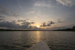 Lac-Toho;Ouidah;Bénin;Afrique-de-lOuest;coucher-de-soleil;heure-dorée;pirogue;proue;ciel-orange;nuages;reflet-lumineux;traversée-lacustre;point-de-vue;voyage;paysage-Afrique-de-lOuest;Tarek-Charara;Kaleidos;Kaleidos-images;La-parole-à-limage