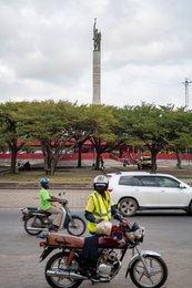Benin;-Cotonou;-Helmet;-High-visibility-vest;-Intersection;-Kaleidos;-Kaleidos-images;-La-parole-à-limage;-Monument;-Motorcycle-taxi;-Place-de-lÉtoile-Rouge;-Red-star;-Roundabout;-Statue;-Stories-Pictures;-Tarek-Charara;-Urban-traffic;-Vehicle;-West-Africa;-Zemidjan