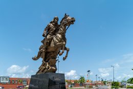 Afrique-de-lOuest;-Bénin;-Bio-Guéra;-Carrefour-Erevan;-Cavalier;-Cheval-cabré;-Ciel-dégagé;-Cotonou;-Enseigne-publicitaire;-Fonte-de-cuivre;-Immeuble-commercial;-Kaleidos;-Kaleidos-images;-La-parole-à-limage;-Monument;-Patine-dorée;-Patrimoine-historique;-Prince-wasangari;-Sculpture;-Statue-équestre;-Tarek-Charara